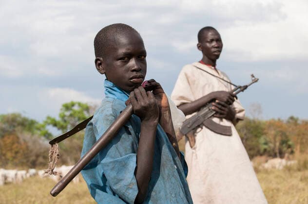 South Sudan, Dinka tribe SOUTH SUDAN, Lakes State, Cueibet , Gok Dinka tribe protect their Zebu cow cattle herds with Kalashnikov AK-47 rifle against hostile cattle raider *** SÜDSUDAN, Lakes State, Cuibet, Dinka Hirten schuetzen ihre Herden mit Zeburindern vor Viehdiebstaehlen von feindlichen Clans mit einem Kalaschnikow AK 47 Maschinengewehr, rechts Hirte Matur 18 Jahre und sein Bruder Makuei 11 Jahre Cuibet Lakes South Sudan