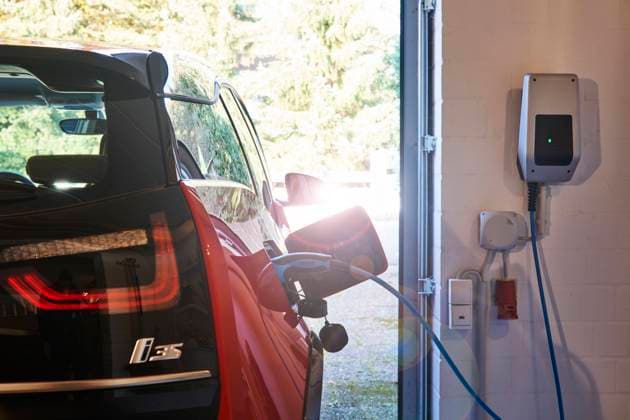 Ein Elektroauto BMW i3 beim Laden an der Wallbox zuhause in der Garage, Lichtreflex E-Auto aufladen *** An electric car BMW i3 charging at the wallbox at home in the garage, light reflex E car charging