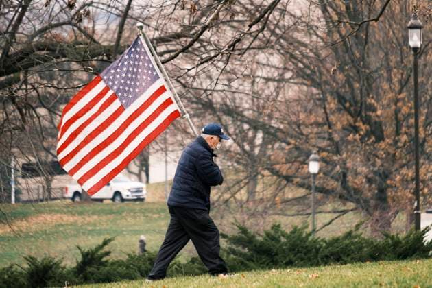 December 6, 2020, Des Moines, Iowa, U.S: A supporter of President Donald Trump carries an American flag during a Trump motorcade at the Iowa State Capitol. About 1,000 supporters of outgoing US President Donald Trump rallied in Des Moines Sunday to show their support for the President and to protest the outcome of the US Presidential election. They started with a rally in the suburbs of Des Moines then drove in a motorcade through the city, ending at the State Capitol. They repeated many of Trump s discredited claims that the election was marked by fraud and that Trump actually won. The protest was a part of the national March for Trump effort, culminating in a march in Washington DC on December 13. Joe Biden won the election, with 306 - ZUMAk94_ 20201206_zaf_k94_028 Copyright: xJackxKurtzx