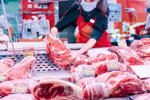 butcher woman placing meat on the counter Madrid, Community of Madrid, Spain CR_IVAR201207-588629-01 ,model released, Symbolfoto