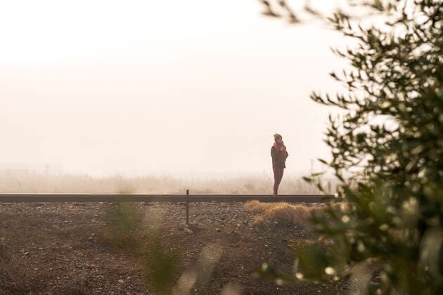 IMAGO Creative: Jahreszeit Winter, Spaziergang Thoughtful woman standing on a foggy railroad while looking away Cintruénigo, Navarre, Spain CR_RAFE201201D-561416-01 ,model released, Symbolfoto