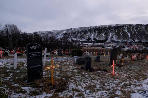 Mit elektrischen Grabkreuzen in bunten Farben beleuchtete Gräber auf dem Friedhof der Lágafellskirkju nahe Mosfellsbær. Die Gräber werden zur Weihnachtszeit geschmückt um auch den Ahnen Licht in der dunklen Jahreszeit zu bringen. Traditionell besucht man an den Weihnachtsfeiertage auch die Gräber der Verstorbenen Erleuchteter Friedhof
