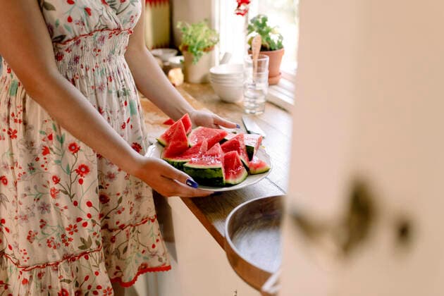 Midsection of female teenager holding watermelon plate at kitchen counter, MA82770, Sweden, Stockholm Archipelago, model released, property released Copyright: xMaskotx