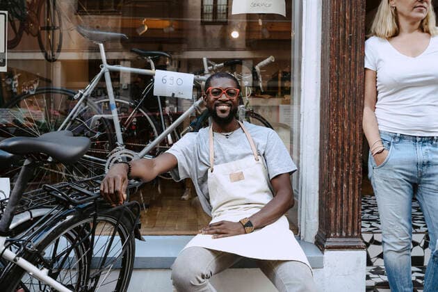 IMAGO Creative: Kreative Renaissance -- der junge Entrepreneur Portrait of confident owner sitting against bicycle shop, MA82932, Germany, Berlin, model released, property released Copyright: xMaskotx