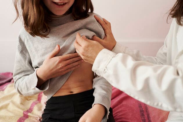 Female doctor teaching the temperature on a thermometer to a girl in her bed. Home doctor concept Pamplona, Navarre, Spain CR_SEBO201210E-575525-01 ,model released, Symbolfoto