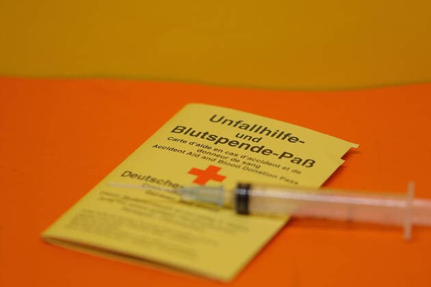 Weltblutspendetag am 14. Juni Frankenberg, Deutschland 13. Dezember 2020: Ein Pass für Unfallhilfe und Blutspende liegt auf einem orangen Untergrund, auf dem Blutspende-Paß liegt eine Spritze Hessen *** Frankenberg, Germany 13 December 2020 A passport for accident assistance and blood donation lies on an orange background, on the blood donation passport lies a syringe Hessen Copyright: xFotostandx xFreitagx