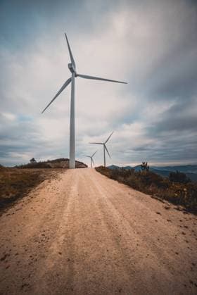 IMAGO Creative: Klimawandel - Zukunft und Innovation Row of modern windmills standing on side of narrow countryside road on cloudy day Copyright: xAlbertoxMenendezx Model Released