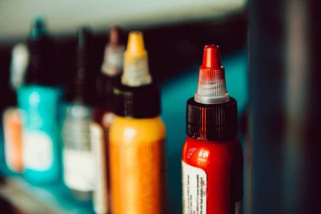Set of small bottles with various tattoo pigments standing on shelf in studio Copyright: xAlbertoxMenendezx Model Released