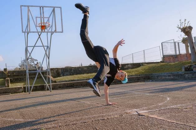 Teenager break dancing on sports ground, Model released Copyright: xAlbertoxMenendezx MR