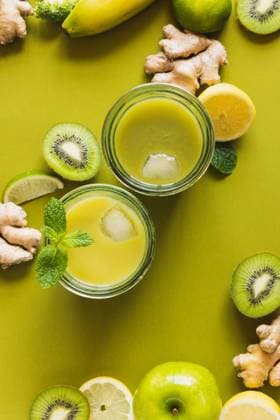 From above of glasses with healthy detox drinks with ice cubes placed on wooden tray with apple and ginger Copyright: xAllaxMachuttx Model Released