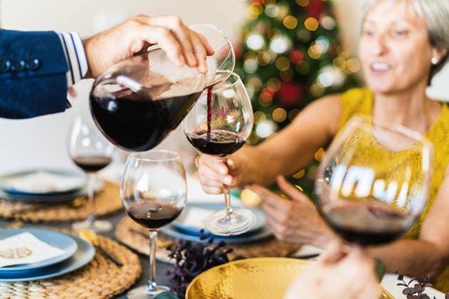 Crop view of hand of anonymous old man serving red wine during Christmas dinner, Model released Copyright: xAlvaroxSanchezx MR