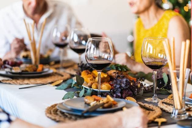 Dining table served with glasses and plates against blurred glowing Christmas tree on Christmas eve at home, Model released Copyright: xAlvaroxSanchezx MR