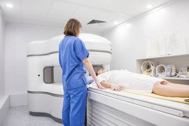 Middle-aged woman and her doctor in an open MRI machine waiting for the test to start, Model released Copyright: xDavidxFuentesx MR