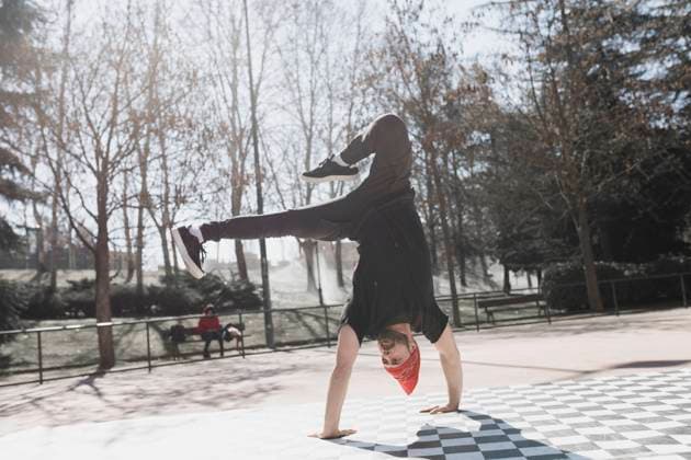 Young athletic guy practicing break dance in park in sunny weather Copyright: xDavidxGailx Model Released