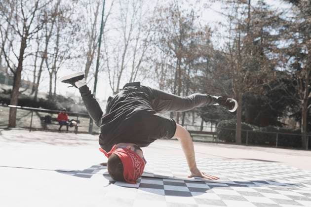 Young athletic guy practicing break dance in park in sunny weather Copyright: xDavidxGailx Model Released