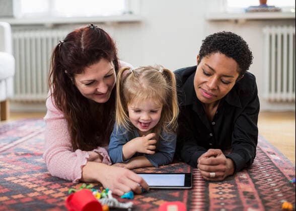 Smiling lesbian couple and girl using digital tablet at home , model released Copyright: xMaskotx , MA40874