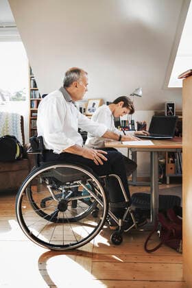Side view of disabled man looking at son studying at home , model released, property released Copyright: xMaskotx , MA45463