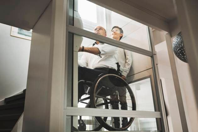 Low angle view of son and father in wheelchair lift at home , model released, property released Copyright: xMaskotx , MA45487