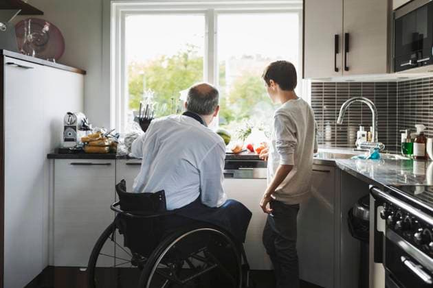 IMAGO Creative, Gesellschaft, Immer mehr Menschen haben Angst vor der Zukunft Disabled father preparing food son in kitchen , model released, property released Copyright: xMaskotx , MA45490