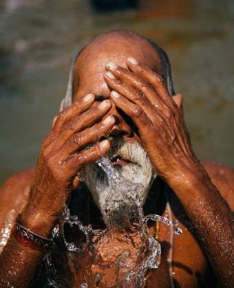 IMAGO Creative: 2021 Favoriten Allahabad, India - February, 2018:gray-haired man splashing and performing ritual bath in water in Prayag Kumbh Mela Festival Copyright: xEkaitzxGeriquex Model Released