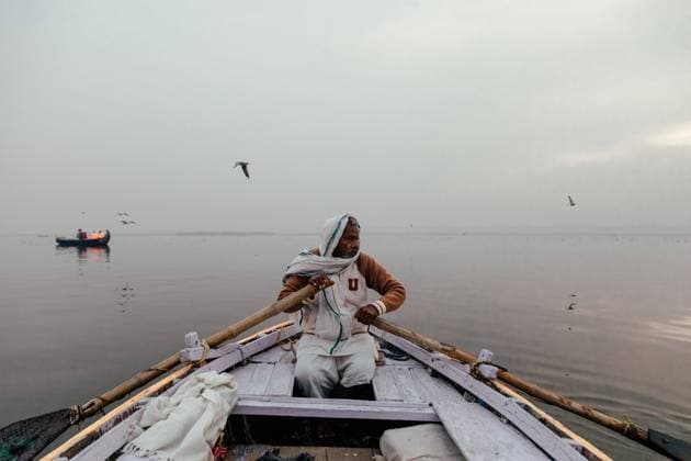 Varanasi, India - February, 2018: Indian male in white clothes sitting in boat and rowing over river Copyright: xEkaitzxGeriquex Model Released