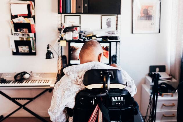 Rear view of disabled musician sitting on wheelchair in recording studio , model released Copyright: xMaskotx , MA48693