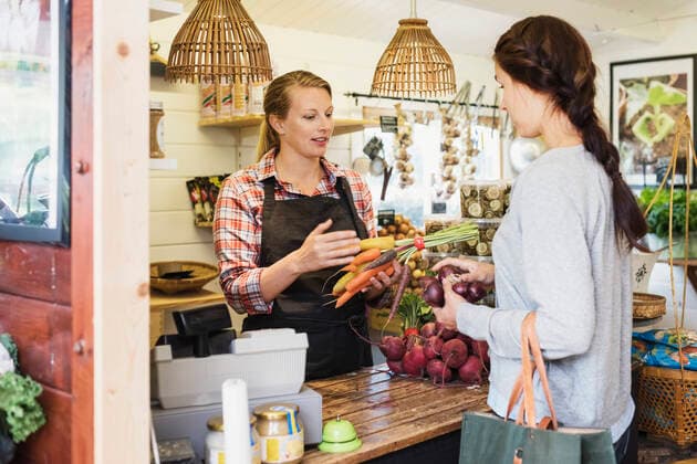 Female customer talking with cashier at health food store , model released Copyright: xMaskotx , MA49335