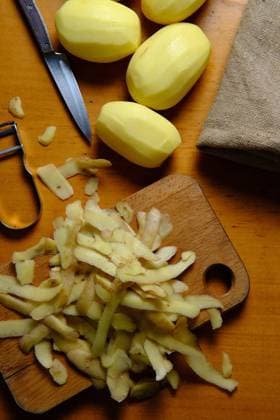 Top view of peeled potatoes and potato peels on cutting board with knife in modern kitchen Copyright: xFatimaxGuisadox Model Released