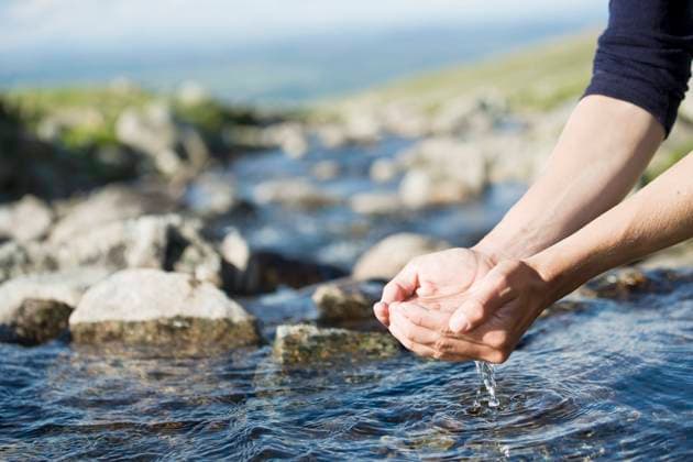 Cropped image of hiker s hands holding water over stream , model released Copyright: xKentarooxTrymanx , MA49912