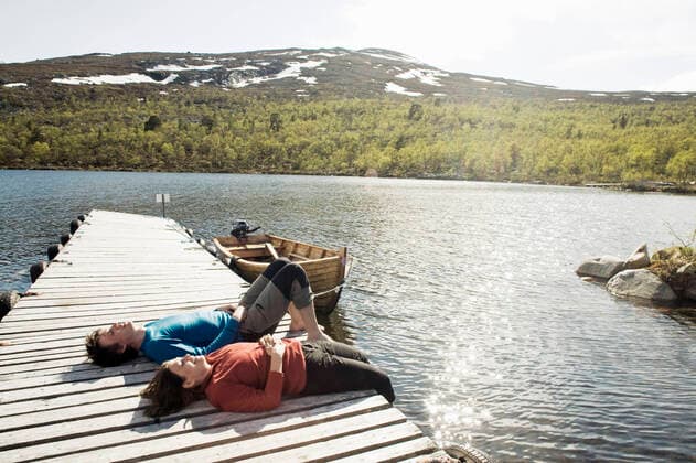 Happy friends relaxing on jetty over lake during sunny day , model released Copyright: xKentarooxTrymanx , MA49921