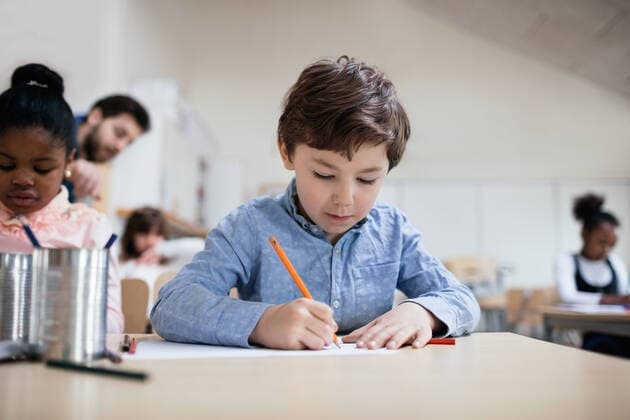 IMAGO Creative: Bildung, Schreiben Serious boy studying while sitting in classroom at school , model released, property released Copyright: xMaskotx , MA51336