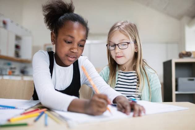 Girl assisting friend while studying in classroom at school , model released, property released Copyright: xMaskotx , MA51338