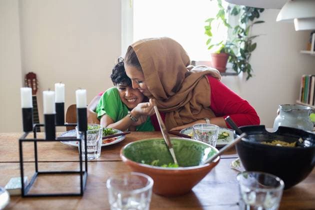 Happy mother and son embracing at dining table , model released, property released Copyright: xMaskotx , MA51727