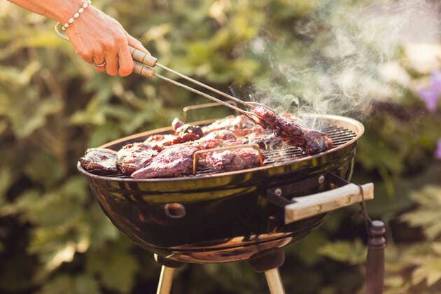 IMAGO Creative: Clickbait, Rezepte und Kochen Cropped hand of woman grilling meat with serving tongs in back yard on sunny day , model released, property released Copyright: xMaskotx , MA53468