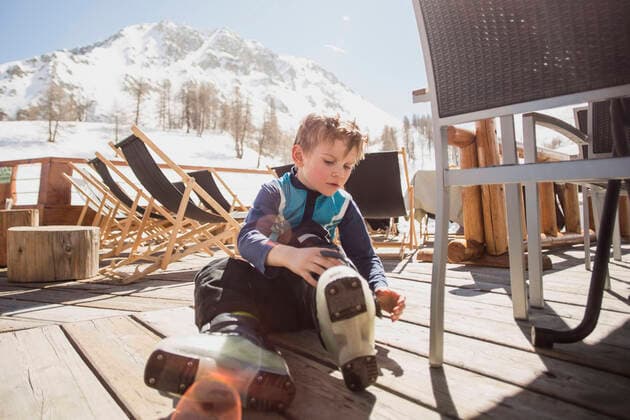 Boy wearing ski boots by seat on floorboard , model released Copyright: xMaskotx , MA54087