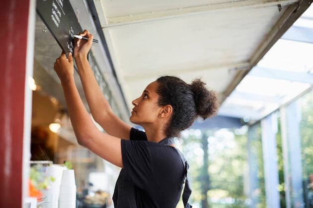 Side view of young waitress writing on menu at cafe , model released, property released Copyright: xMaskotx , MA54565