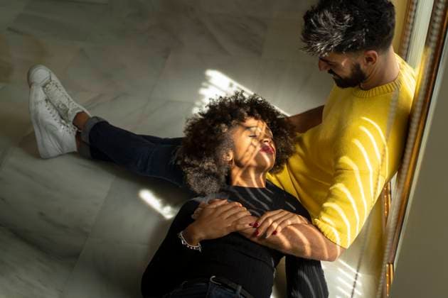 Pretty African American female with closed eyes peacefully lying on knees of bearded man in stylish room, Model released Copyright: xFranxRosadox MR