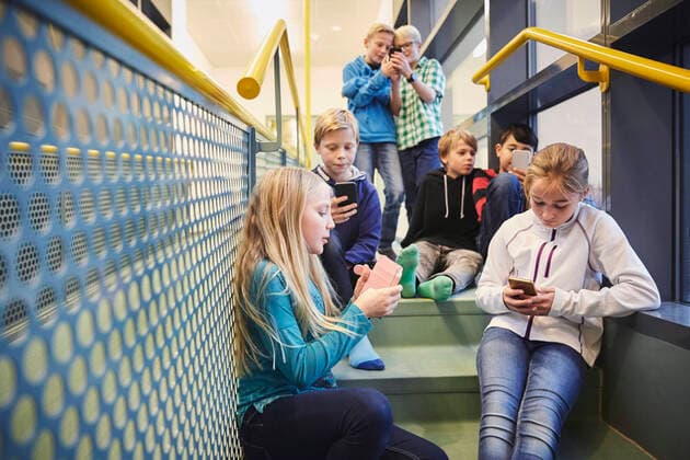 Junior high students using smart phones in school , model released, property released Copyright: xMaskotx , MA54992