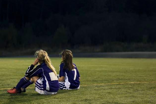 Rear view of girls relaxing on soccer field , model released Copyright: xMaskotx , MA55662