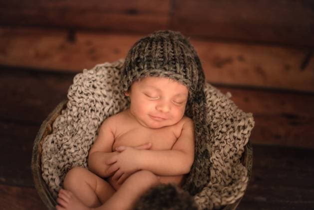 IMAGO Creative: Gesundheit, Stille nude infant in knitted hat sleeping in bucket on wooden floor at home Copyright: xGabrielxTrujillox Model Released