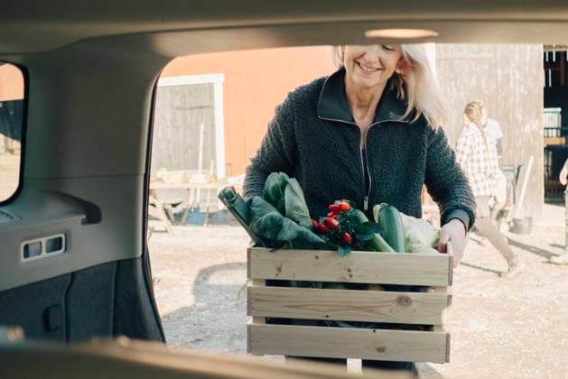 Mature woman loading crate full of organic vegetables in car trunk , model released, property released Copyright: xMaskotx , MA60641