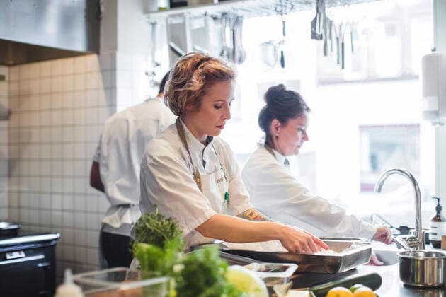 Female chefs preparing food on counter by colleagues in kitchen at restaurant , model released, property released Copyright: xMaskotx , MA61486