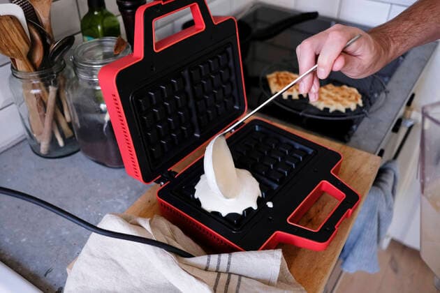 IMAGO Creative: Clickbait, Rezepte und Kochen Cropped image of man pouring batter on waffle iron at kitchen counter , model released, property released Copyright: xMaskotx , MA61946