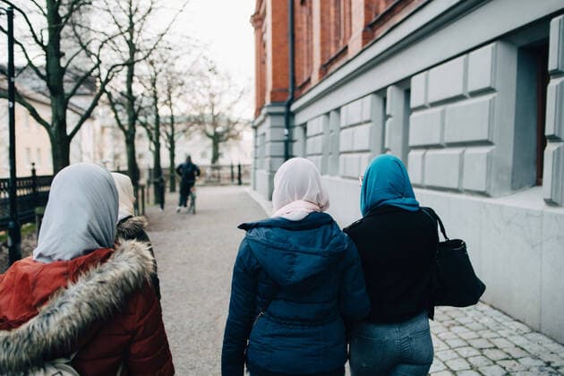 IMAGO Creative: Kollidierende Kulturen Rear view of females walking on footpath by building in city , model released Copyright: xMaskotx , MA62043