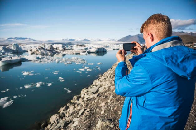 Tourist taking a photo at Jokulsarlon Glacier Lagoon, a glacial lake filled with icebergs in South East Iceland Jokulsarlon Europe South East Iceland Iceland Copyright: xMatthewxWilliams-Ellisx MWE_15346