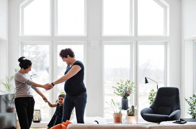 IMAGO Creative: Pride Month 2022, Engagement der Jugendlichen Mothers and daughter holding hands while playing in living room at home , model released, property released Copyright: xMaskotx , MA63079