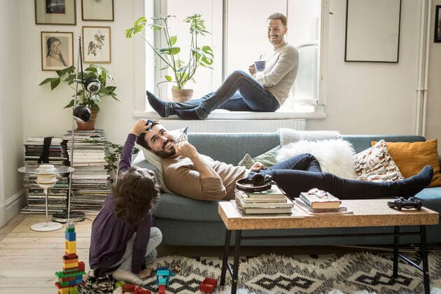 Girl playing with fathers while man sitting on window sill in living room , model released, property released Copyright: xMaskotx , MA64209