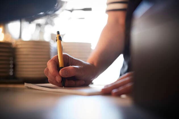 Cropped image of barista preparing checklist at checkout counter , model released, property released Copyright: xMaskotx , MA64474