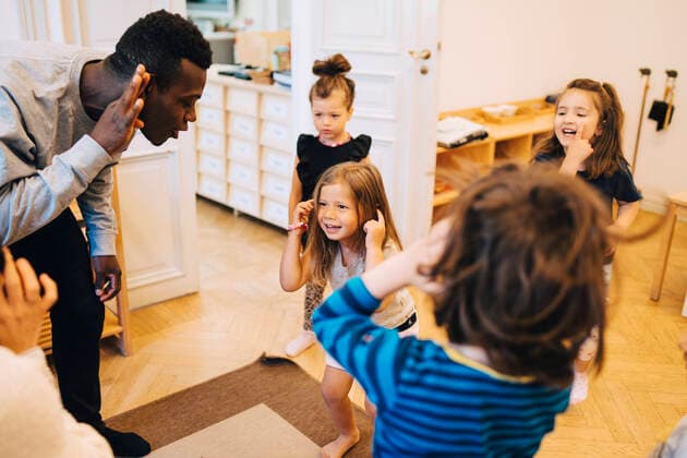 High angle view of teachers and students dancing in classroom at child care , model released, property released Copyright: xMaskotx , MA65878