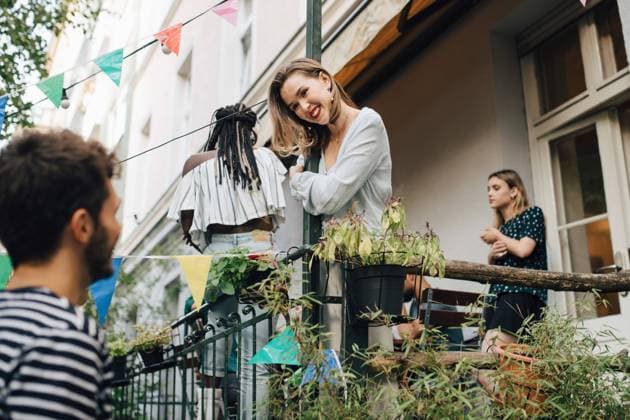 Smiling young woman looking at male friend while standing in balcony during garden party , model released, property released Copyright: xMaskotx , MA68043